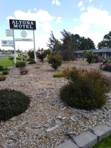 a sign for a aloha motel in a yard at Altona Motel in Uralla