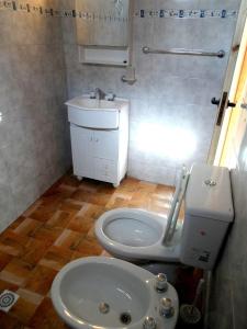 a small bathroom with a toilet and a sink at Las golondrinas in San Clemente del Tuyú