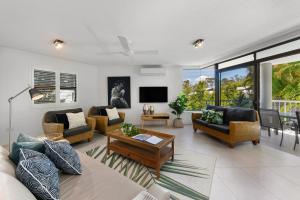 - un salon avec des canapés, une table et une télévision dans l'établissement Naousa II Apartment 5, Little Cove, à Noosa Heads
