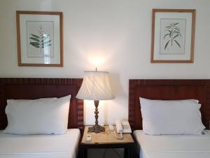 a hotel room with two beds with a lamp and a phone at Charming La Casita Mercedes, 5Br and 5TB for Family and Friends Staycation- Read Listing Info in Manila
