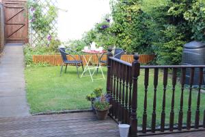 a fence with a table and chairs in a yard at Potters House Coventry warwickshire in Coventry