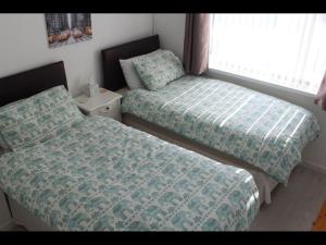 a bedroom with two beds and a window at Potters House Coventry warwickshire in Coventry