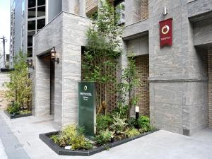 a building with a sign on the side of it at Amistad Hotel Fukuoka in Fukuoka