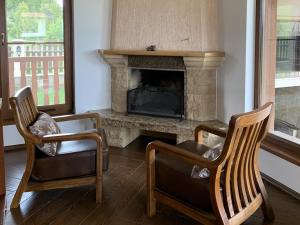 a living room with two chairs and a fireplace at Вили Чала in Chala