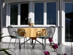 a table and chairs with a yellow table cloth on it at Millenniumshof in Caldaro