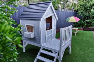 a play house with a chair and an umbrella at The Shack Noosa in Noosa Heads