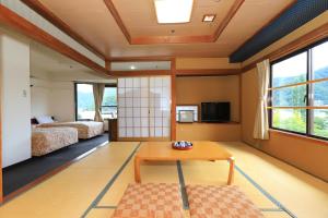 um quarto com duas camas e uma mesa num quarto em Shiki-no-Yado Fujisan em Fujikawaguchiko