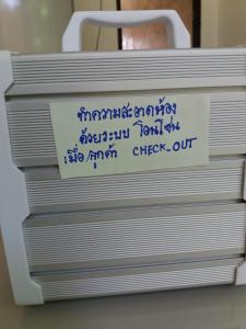 une pile de boîtes métalliques avec écriture sur celles-ci, dans l'établissement Raina-Suanpa Lung Sood Farmstay, à Suphanburi