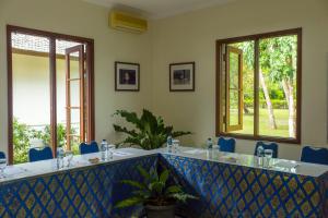 um quarto com uma banheira com cadeiras azuis e janelas em Rungan Sari Meeting Center & Resort em Guhung mais 28 fotografias