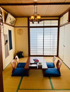 een woonkamer met een tafel en blauwe stoelen bij KR Apartment in Kanazawa in Kanazawa