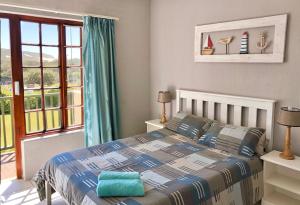 a bedroom with a bed and a large window at 42 Settler Sands Beachfront Accommodation Sea and River View in Port Alfred