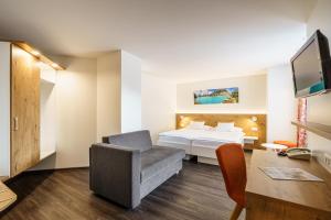 Habitación de hotel con cama y silla en Hotel Bernerhof en Interlaken