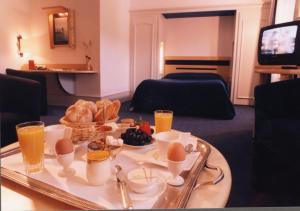 een dienblad met eten op een tafel in de woonkamer bij Logis Hotel le France in Villers-le-Lac