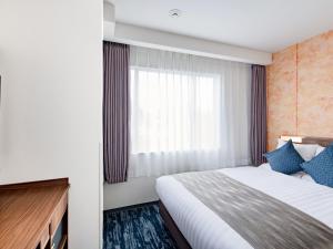 a hotel room with a bed and a window at Art Hotel Kagoshima in Kagoshima