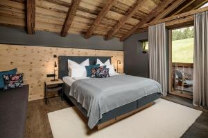 a bedroom with a bed and a large window at BergWärtsGeist SENHOOG Luxury Holiday Homes in Leogang