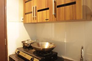 a kitchen with two bowls on top of a stove at Spacious Studio Room at Gateway Pasteur Apartment near Exit Toll Pasteur By Travelio in Bandung