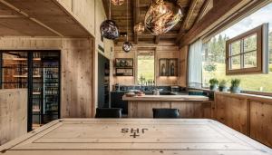 a kitchen with wooden walls and a table with chairs at GipfelKreuzLiebe Senhoog Luxury Holiday Homes in Leogang