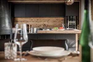 uma cozinha com uma mesa com pratos e copos de vinho em BergWärtsGeist SENHOOG Luxury Holiday Homes em Leogang