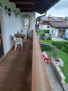 a wooden deck with a table in a backyard at Haus Singer in Bad Feilnbach