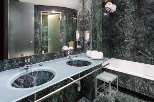 Un baño con dos lavabos y un espejo grande. en B&B HOTEL Jerez, en Jerez de la Frontera