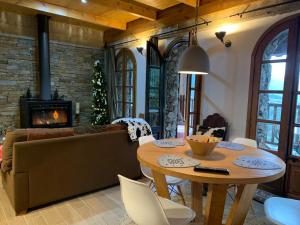 a living room with a table and a couch and a fireplace at Casa Rural Pirineu Nevà in Nevà
