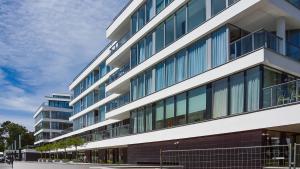 a large building with glass windows on a street at VacationClub – Dune B Apartament 3.22 in Mielno