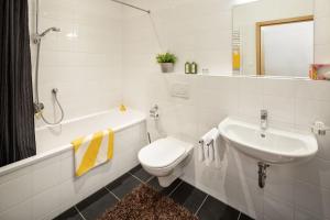 a white bathroom with a sink and a toilet at Fewo-Obertauern-Steinadler in Obertauern +9 photos