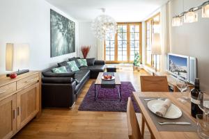 a living room with a black couch and a table at Fewo-Obertauern-Steinadler in Obertauern