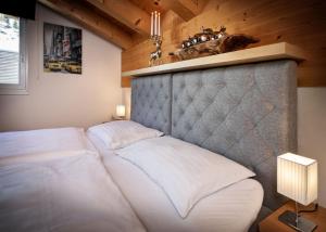 a bedroom with a white bed with a head board at Fewo-Obertauern Alps in Obertauern