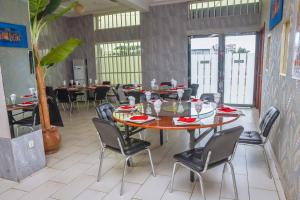 a restaurant with tables and chairs in a room at White Horse Hotel Cotonou in Agblangandan