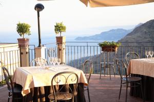 two tables and chairs on a balcony with a view at Agostiniana Hotel in Forza dʼAgro +4 photos