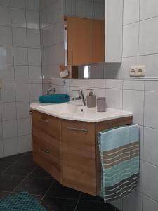 ein Bad mit einem Waschbecken und einem Spiegel in der Unterkunft Ferienwohnung Pusteblume in Wüstensachsen