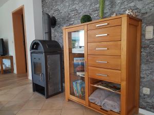 a room with a dresser and a woodburning stove at Ferienwohnung Pusteblume in Ehrenberg