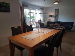 a dining room table with chairs and a living room at Ferienwohnung Pusteblume in Ehrenberg