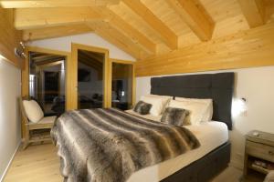 En eller flere senge i et værelse på Chalet Marmotte by Swiss Alps Village