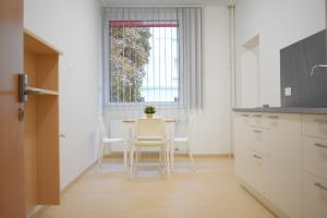 cocina con mesa, sillas y ventana en SOVEA Hotel - City, en Linz