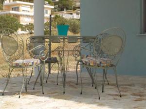 two chairs and a glass table with a table and chairs at Casa Aqua Marina in Aghia Marina