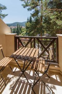a wooden bench sitting on top of a balcony at Bendida Apartments in Velingrad