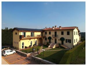 une grande maison avec une voiture garée dans un parking dans l'établissement Villa Benvenuto, à Costermano