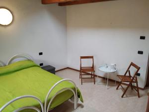 ArsieroにあるAgriturismo Val di Ferroのベッドルーム(緑のベッド、テーブル、椅子付)