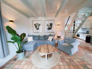 a living room with a blue couch and a table at Cozy historical Cottage (Huisje HèHè) in Wassenaar