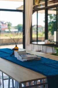 einen Tisch mit einem blauen Tischtuch und einem Buch in der Unterkunft Yindee Home & Cafe in Nan
