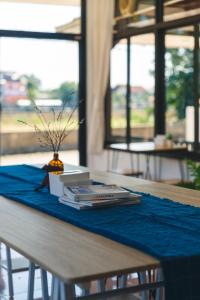 ein Tisch mit einer blauen Tischdecke und einem Buch in der Unterkunft Yindee Home & Cafe in Nan