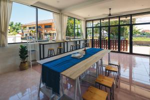 a dining room with a blue table and chairs at Yindee Home & Cafe in Nan