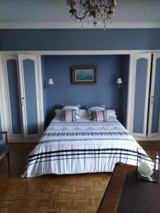 a bedroom with a large bed with blue walls at L'Annexe in Ciboure