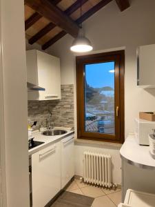 a kitchen with white cabinets and a window and a sink at Casa di Adele in Chiaravalle