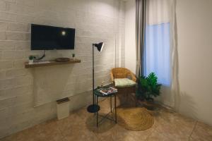 a living room with a table and a tv on a wall at Yindee Home & Cafe in Nan