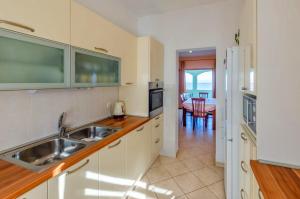 una cucina con lavandino e una sala da pranzo di Seafront Holiday Home Marija a Prigradica