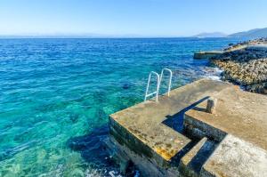 una scala per l'oceano con acqua blu di Seafront Holiday Home Marija a Prigradica