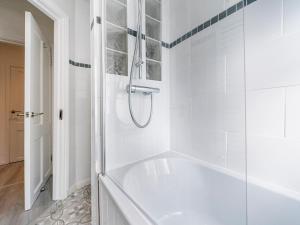 a white bathroom with a tub and a shower at Pass the Keys - Bright & Airy 2BR 2Bath Apt in Perfect Location in Belfast